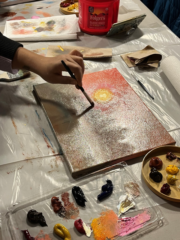 Hand paints a sunset.