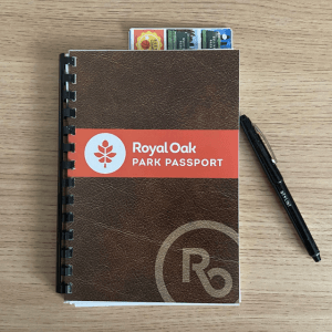 Image of the Royal Oak Park passport on a desk table . Sticker sheets can be seen.